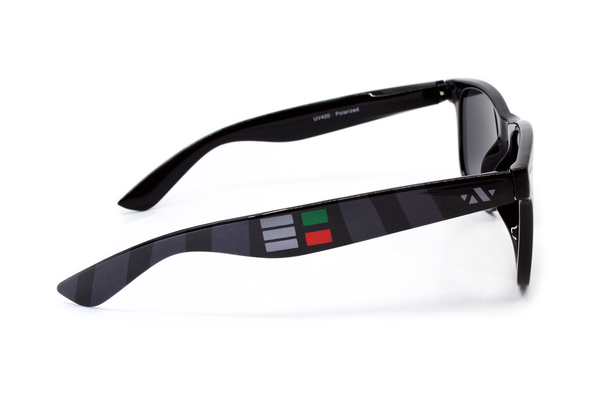 Side view of black sunglasses with detail of grey, red, and green boxes.